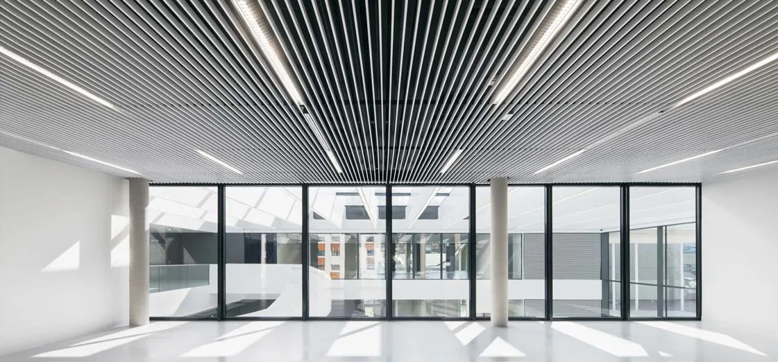 Slatted aluminum ceiling with integrated surface tempering in an open-plan office atrium